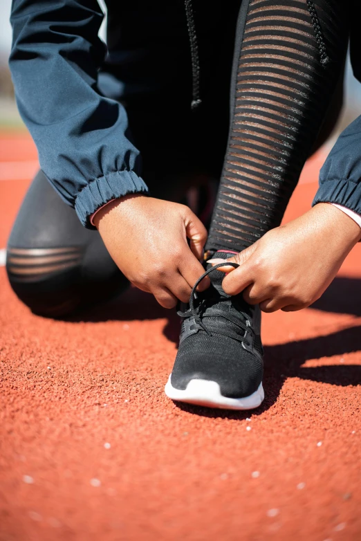 a woman tying up her shoes on a tennis court, trending on unsplash, wearing track and field suit, or black, pacing, textured