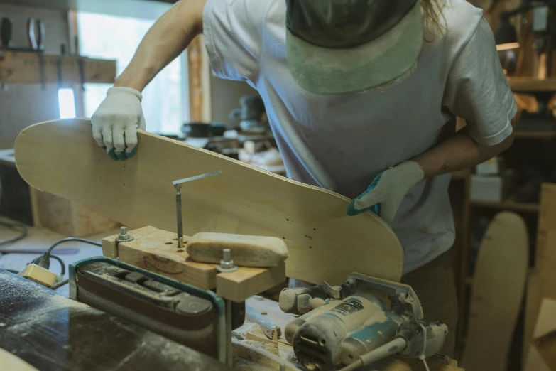 a man working on a skateboard in a workshop, by Jessie Algie, trending on unsplash, curved furniture, carving, thumbnail, profile image