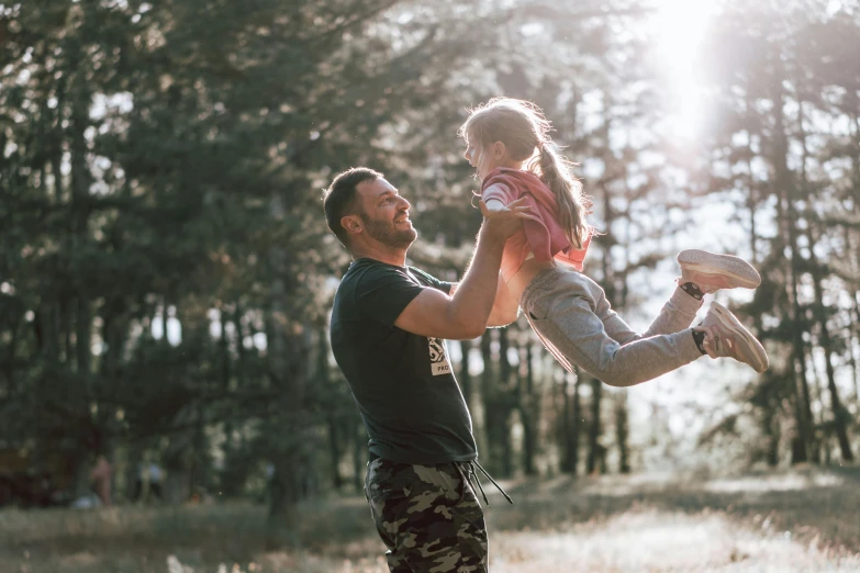 a man holding a little girl up in the air, pexels contest winner, forest picnic, avatar image, manuka, handsome