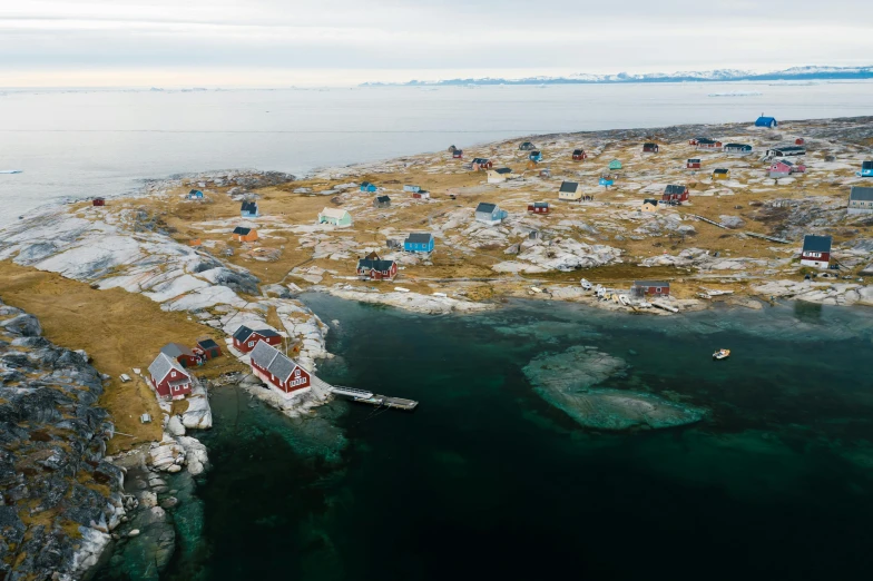 a small village in the middle of a body of water, arctic fish, flatlay, burnt huts, helicopter view