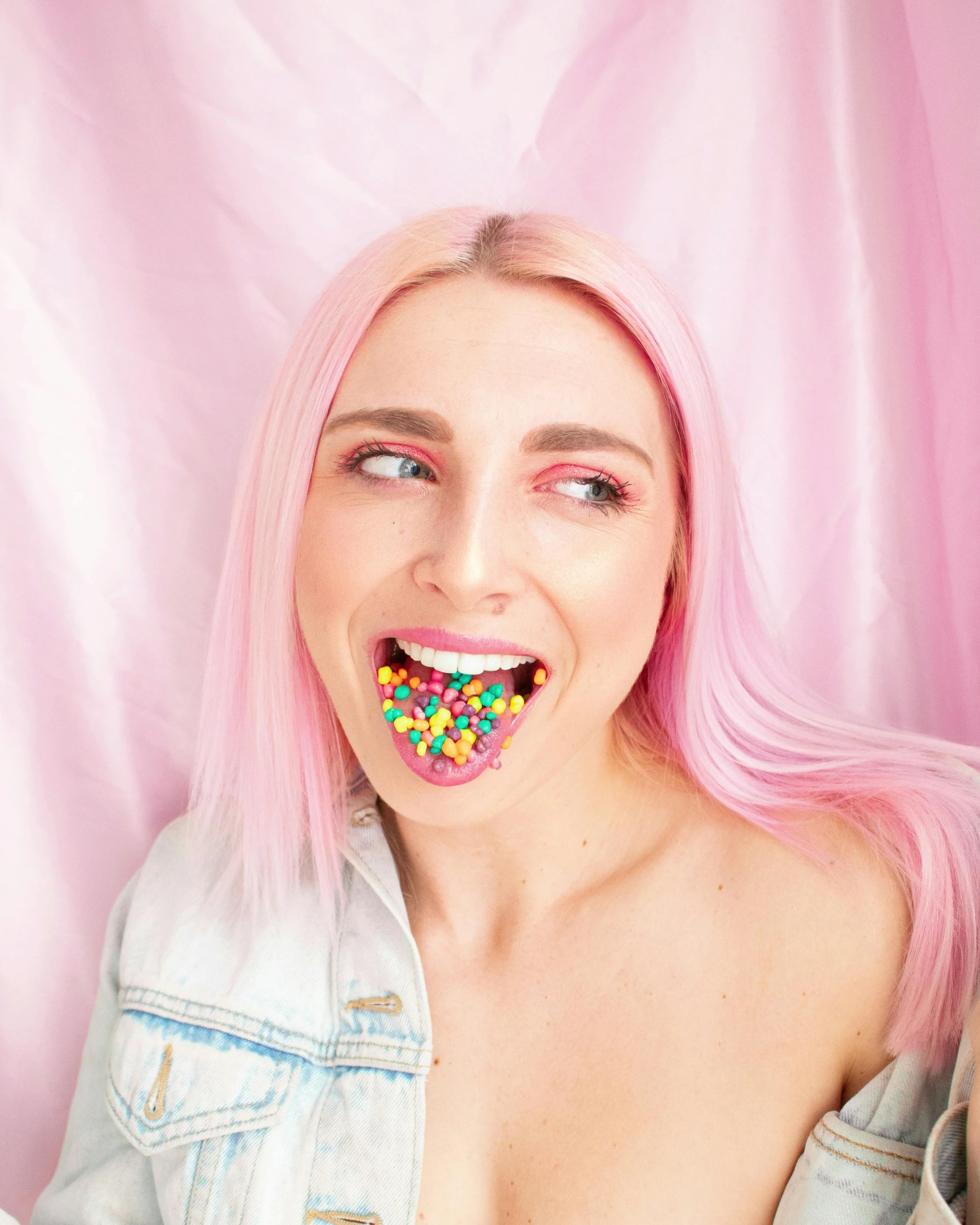 a woman with pink hair and a donut in her mouth, inspired by Hannah Frank, trending on pexels, gummy bears, nonbinary model, cereal, mouth slightly open