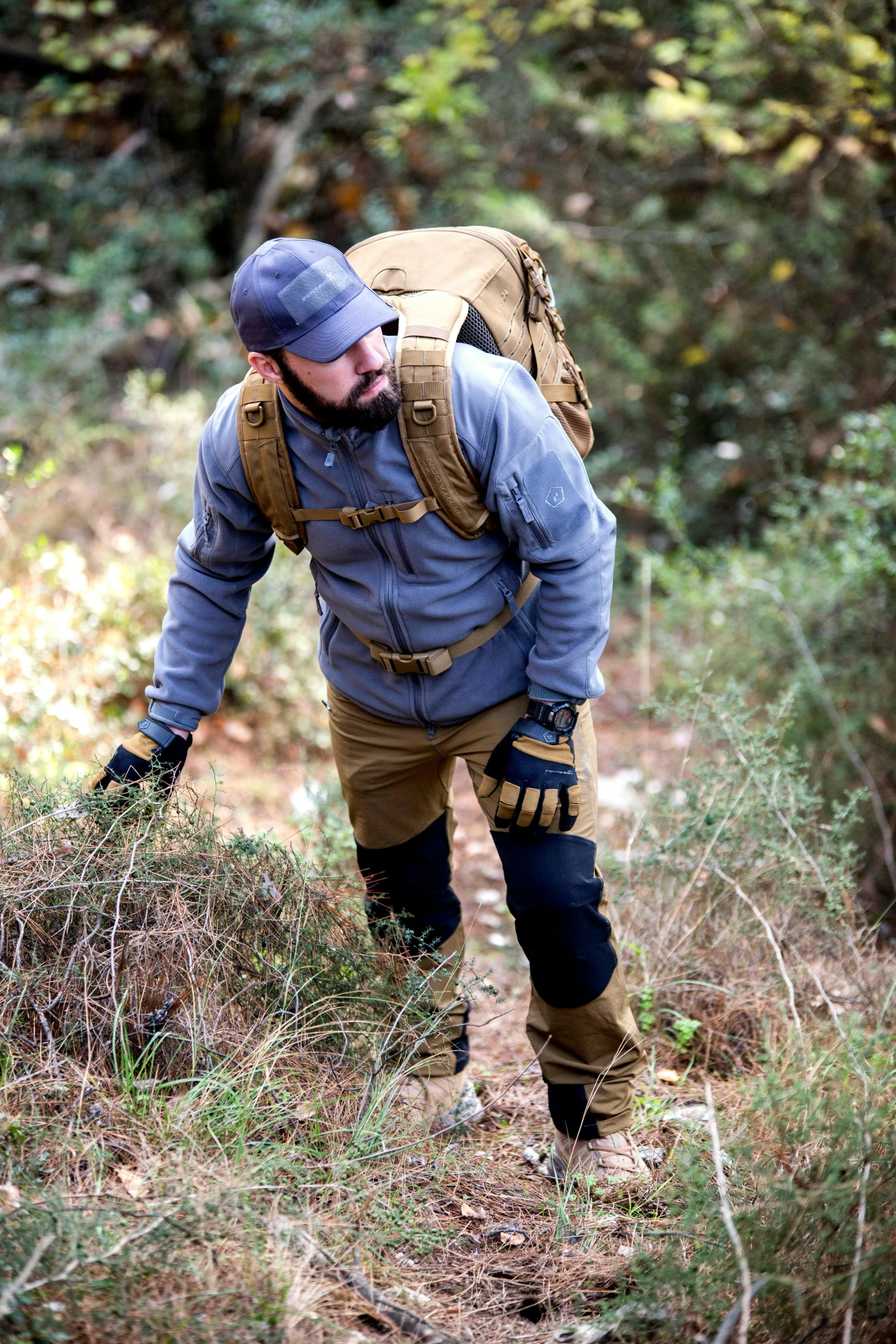 a man walking in the woods with a backpack, lightweight armour, working clothes, rugged beard, kevlar