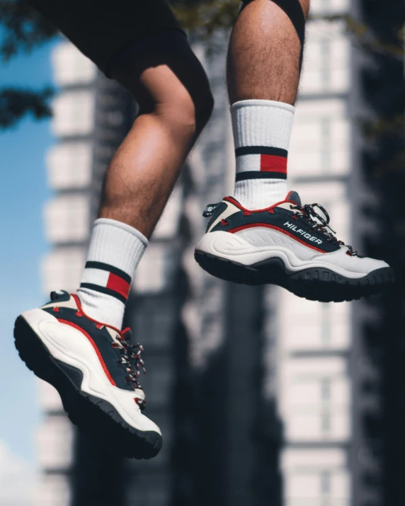 a man flying through the air while riding a skateboard, inspired by Tommaso Redi, trending on unsplash, striped socks, silver white red details, standing on a skyscraper rooftop, 🚿🗝📝