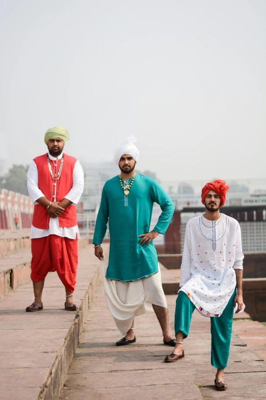 a group of men standing next to each other, an album cover, by Manjit Bawa, pexels contest winner, wearing traditional garb, on a bridge, hips, ( ( theatrical ) )