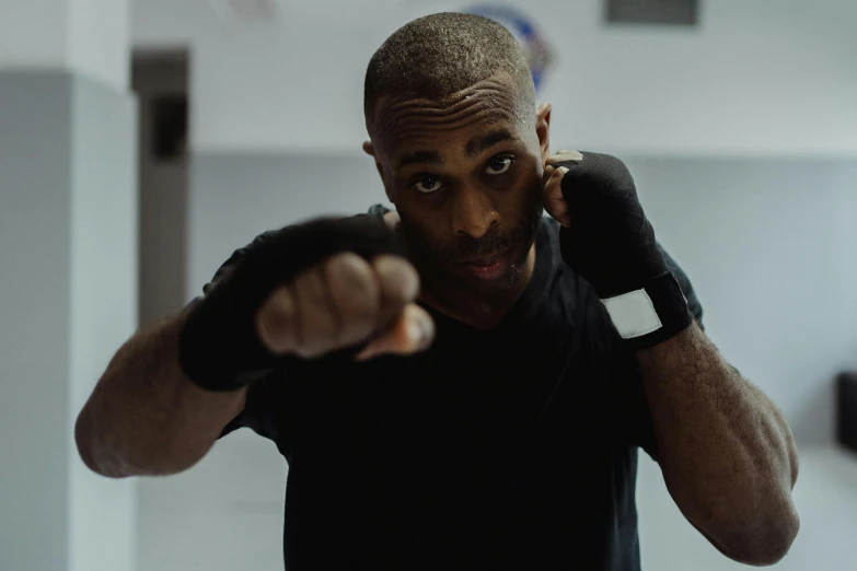 a man in a black shirt pointing at the camera, by Vincent Evans, pexels contest winner, boxing stance, square, mkbhd, local gym