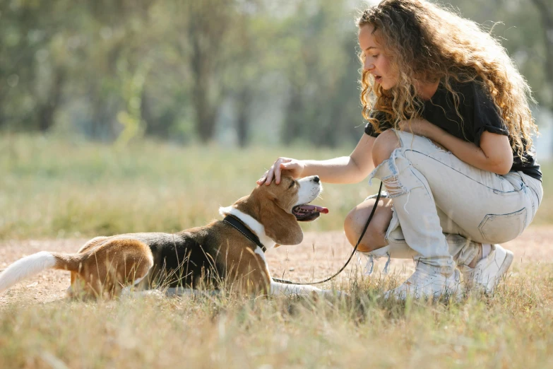 a woman kneeling down petting a dog on a leash, trending on pexels, cute beagle, manuka, thumbnail, looking at the ground