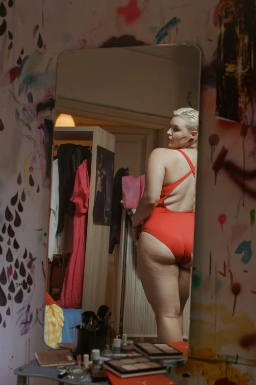 a woman standing in front of a mirror in a room, is wearing a swimsuit, red door blonde, filmstill, pawg