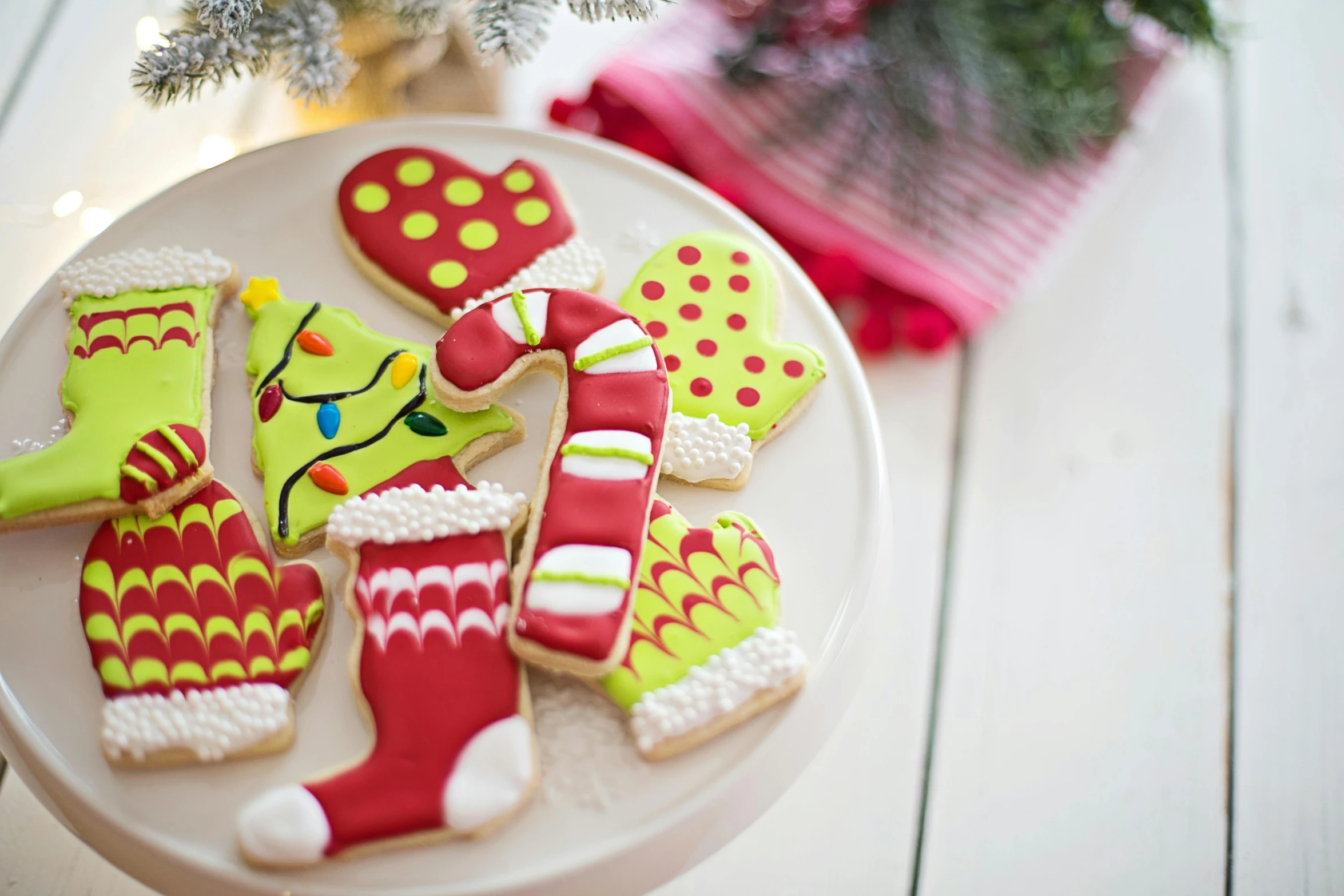 a white plate topped with christmas cookies next to a christmas tree, wearing in stocking, vibrant colour, 3 - piece, olive green and venetian red