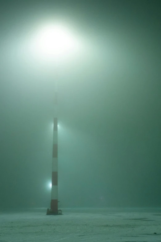a light house sitting on top of a snow covered field, inspired by Michal Karcz, postminimalism, (((underwater lights))), green fog, opposite the lift-shaft, shot on a 2 0 0 3 camera