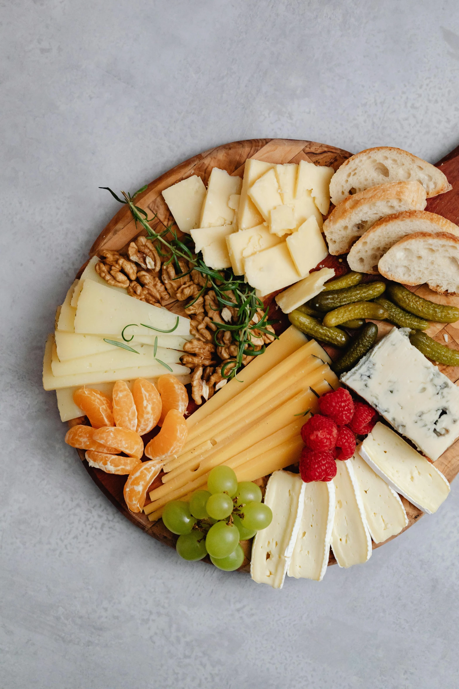 a close up of a plate of food on a table, cheeses, on a gray background, split near the left, vine