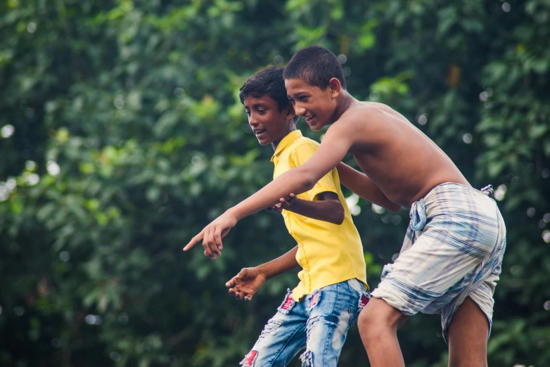 two young boys are playing with a frisbee, by Sam Dillemans, pexels contest winner, happening, amazon indian peoples in brazil, avatar image, dancing on a pole, thumbnail