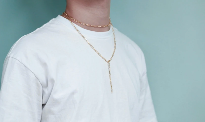 a close up of a person wearing a white shirt, inspired by Jacob Collins, wearing gold chain, rose gold, teenage boy, wearing a parker