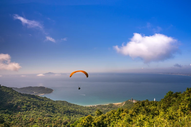 a paraglider flying over a lush green hillside, by Reuben Tam, pexels contest winner, like jiufen, view of the ocean, avatar image, panoramic view