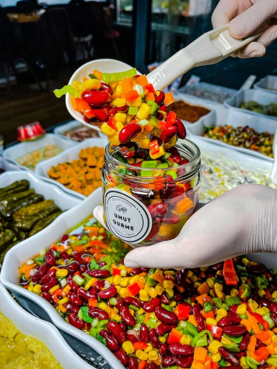 a person scooping jelly out of a jar, by Sam Dillemans, pexels, colored market stand, with colorfull jellybeans organs, salad, mixture turkish and russian