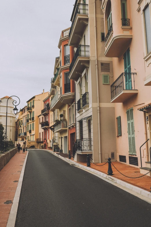 a man riding a skateboard down a street next to tall buildings, pexels contest winner, renaissance, french village exterior, pastel colored, coastal, monaco