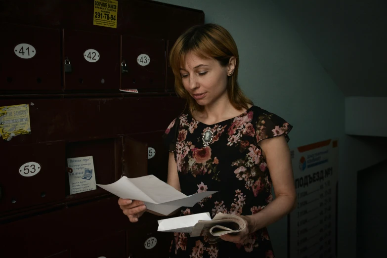 a woman standing in front of a bunch of mail boxes, by Alejandro Obregón, private press, russian academic, in office, document photo, on a dark background