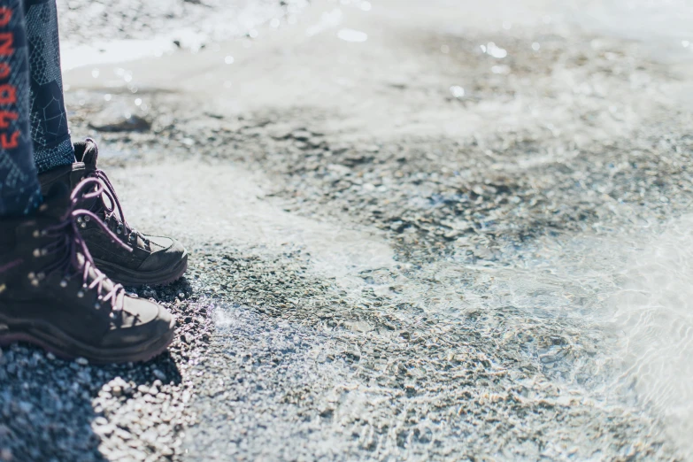 a person standing in front of a fire hydrant, by Julia Pishtar, trending on unsplash, white shorts and hiking boots, covered in salt, sparkling in the sunlight, algae feet