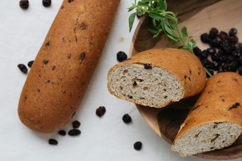 a wooden bowl filled with bread and raisins, inspired by Richmond Barthé, trending on pexels, holding a baguette, panorama, tall, coloured