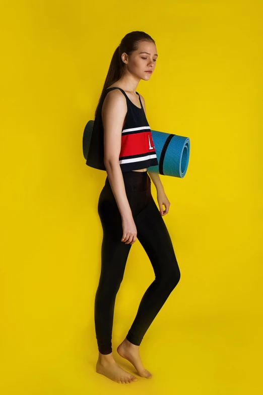 a woman standing in front of a yellow wall, inspired by Mondrian, wearing fitness gear, black+velvet+red+turquoise, neoprene, studio shot