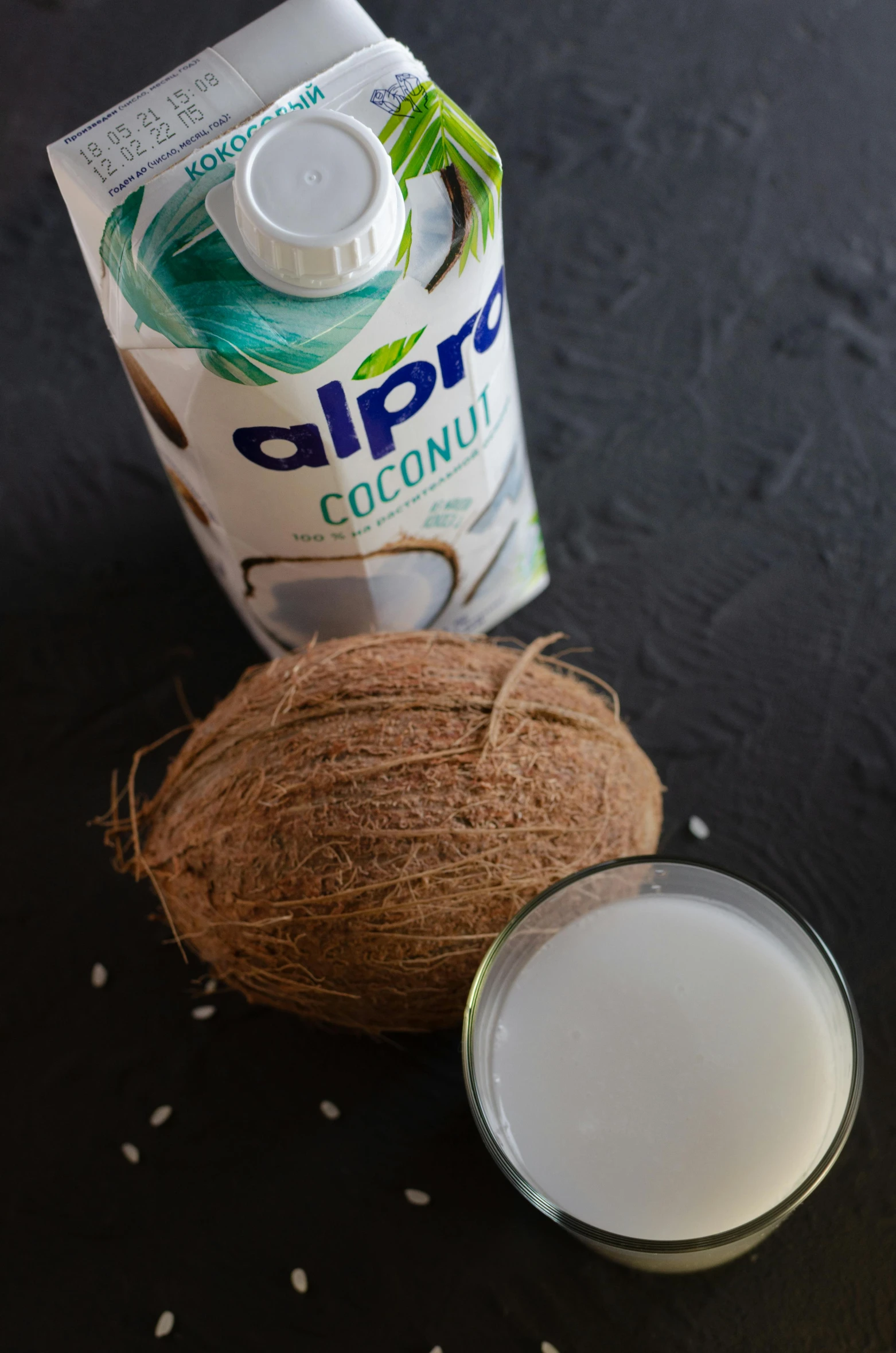 a bottle of coconut milk next to a coconut, a portrait, by Albert Keller, unsplash, dau-al-set, detailed product image, with a black background, soup, square