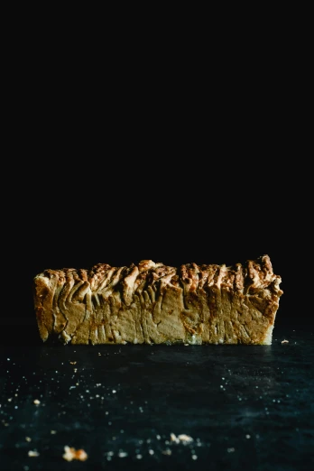 a piece of pie sitting on top of a table, by Dave Allsop, strong texture, on a black background, loaves, whole-length