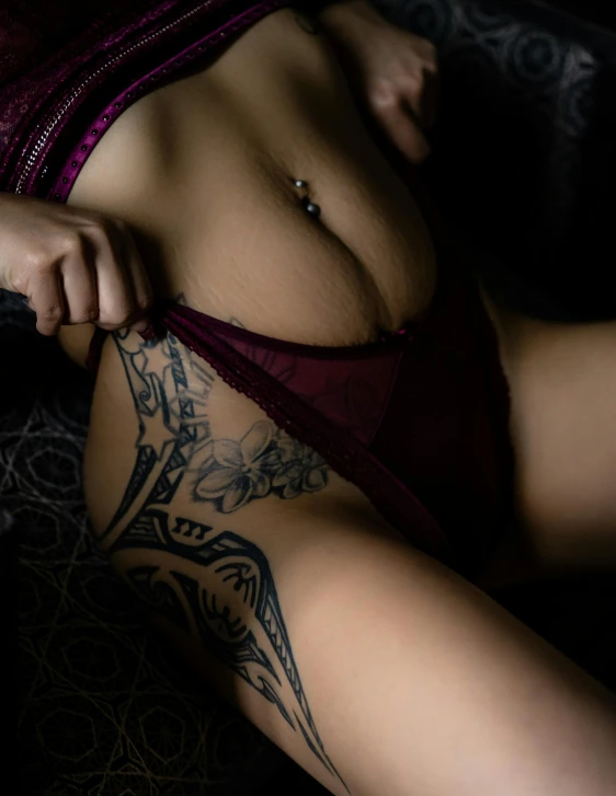 a woman with a tattoo on her chest, by Cosmo Alexander, trending on pexels, art photography, cute panties, seductive seated pose, lower body, low quality photo
