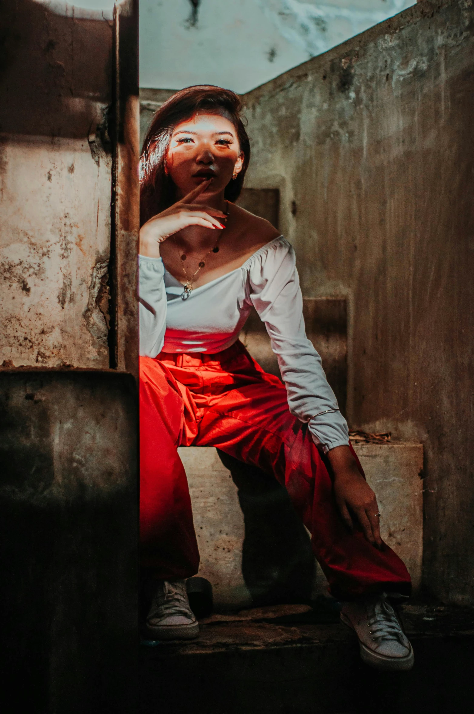 a woman in a white shirt and red pants, inspired by Elsa Bleda, pexels contest winner, renaissance, in a prison cell, vietnamese woman, dramtically lit, posing for a picture