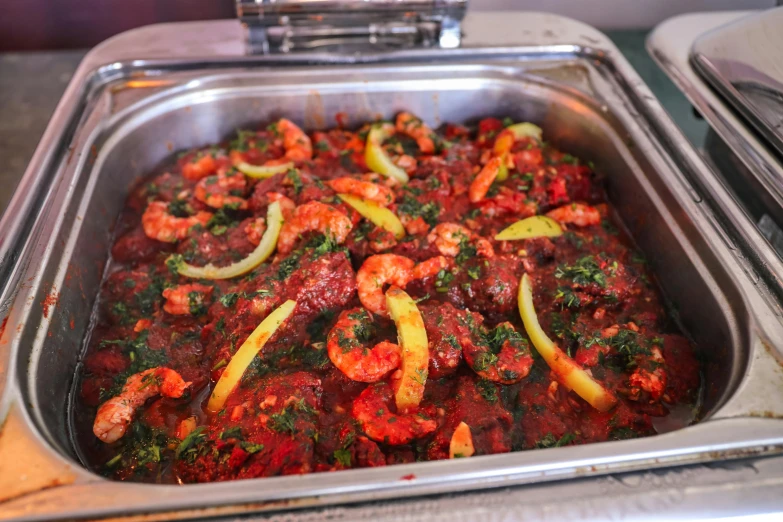 a pan filled with lots of food sitting on top of a counter, hurufiyya, prawn, african ameera al taweel, crimson themed, boston