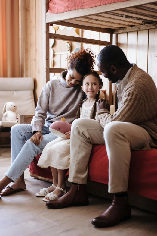 a couple of people that are sitting on a bed, pexels, with a kid, sitting on a mocha-colored table, at the sitting couch, comforting