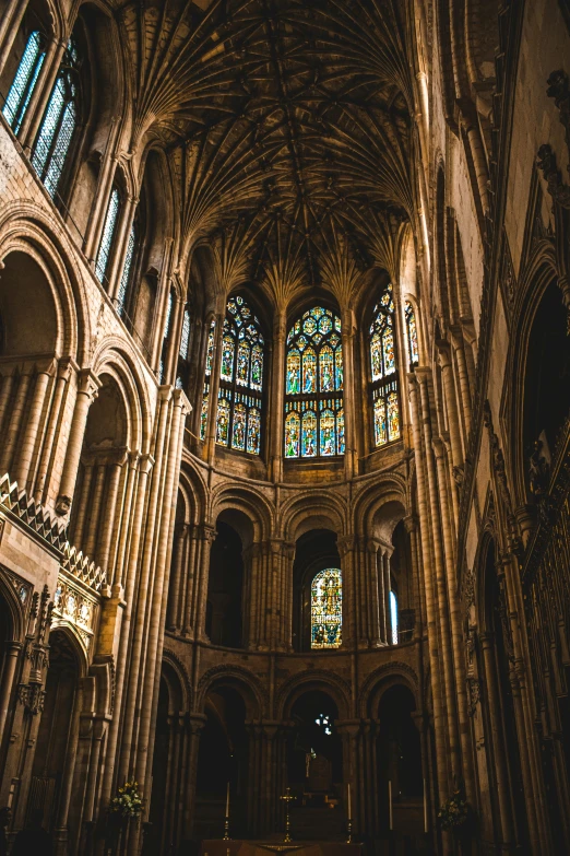 the inside of a cathedral with a stained glass window, gothic art, vibrant but dreary gold, english heritage, spines and towers, overlooking