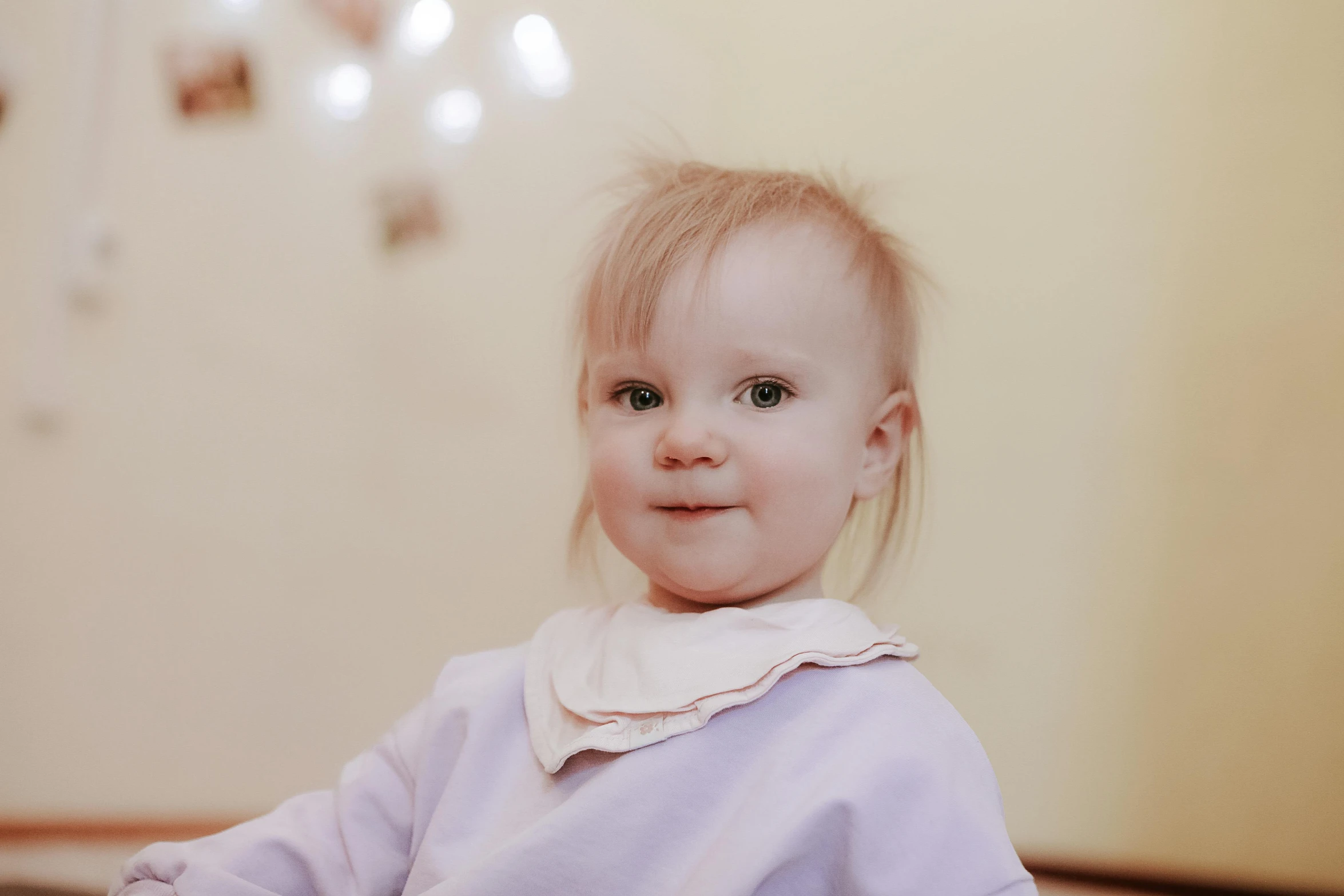 a little girl that is sitting on the floor, by Emma Andijewska, pexels contest winner, close - up on face, angelina stroganova, super cute and friendly, 2 years old