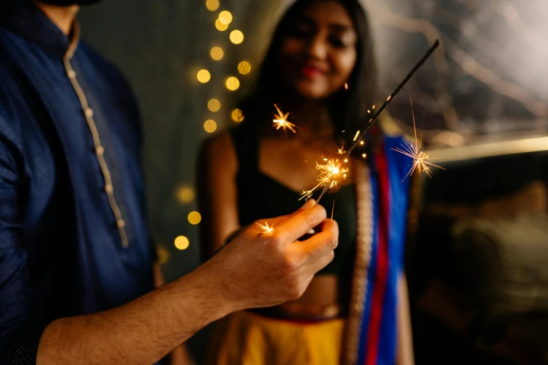 a man and a woman holding sparklers in their hands, pexels contest winner, hurufiyya, indian girl with brown skin, avatar image, wearing festive clothing, thumbnail
