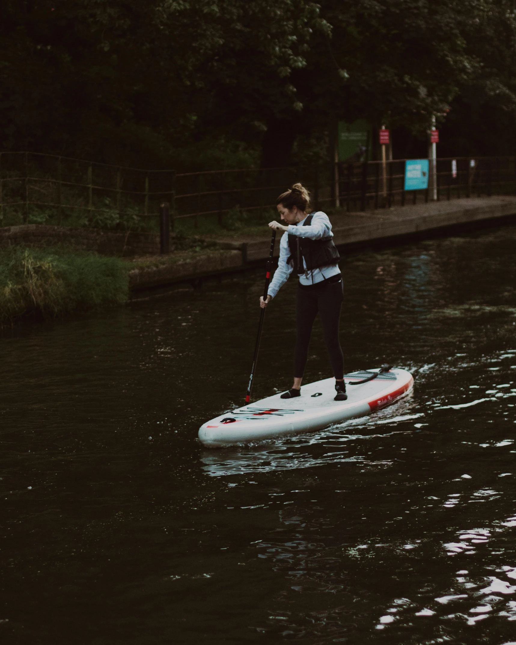 a woman riding a paddle board on top of a river, by Emma Andijewska, slight overcast lighting, charli bowater, canals, splash image