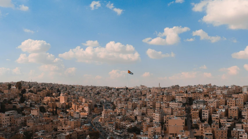 a kite flying in the sky over a city, by Douglas Shuler, pexels contest winner, hurufiyya, lebanon kirsten dunst, slightly pixelated, arabic, jordan