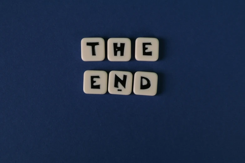 scrabbles spelling the end on a blue surface, an album cover, pixabay, happening, ignant, the end of the word, terminal text, taken in the night