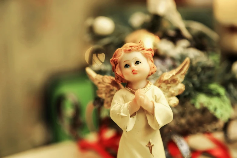 a figurine of an angel standing in front of a christmas tree, trending on pixabay, baroque, innocent look, lofi, blessing hands, retro style ”