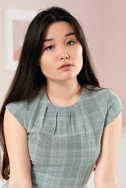 a woman sitting on a bed holding her stomach, inspired by helen huang, hyperrealism, wearing business casual dress, neck zoomed in, frowning, pokimane