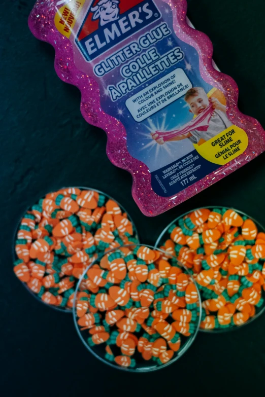 a bunch of candy sitting on top of a table, transparent celestial light gels, orange shoulder pads, detailed product image, sparkels
