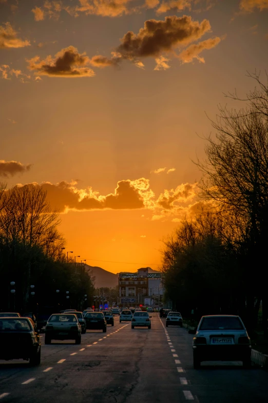 a group of cars driving down a street at sunset, today\'s featured photograph 4k, madrid, large twin sunset, yellow