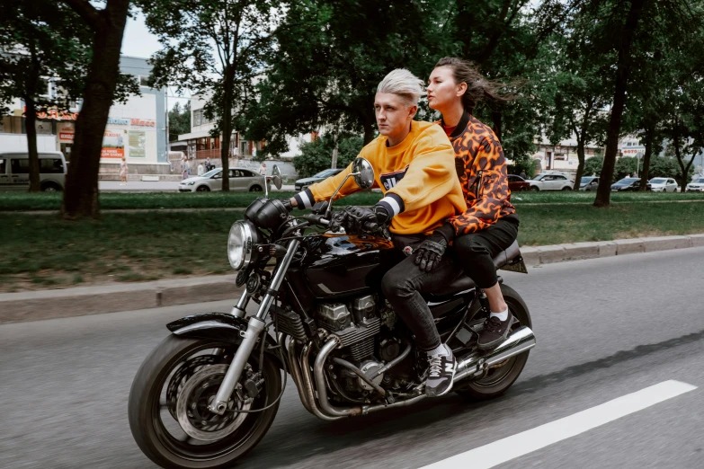 a man and a woman riding on the back of a motorcycle, by Emma Andijewska, pexels contest winner, billie eilish, street clothing, non-binary, andrzej marszalek