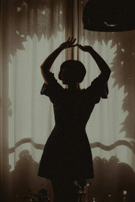 a silhouette of a woman standing in front of a window, inspired by Elsa Bleda, unsplash, arabesque, dancing, retro vintage and romanticism, early 2 0 th century, instagram picture