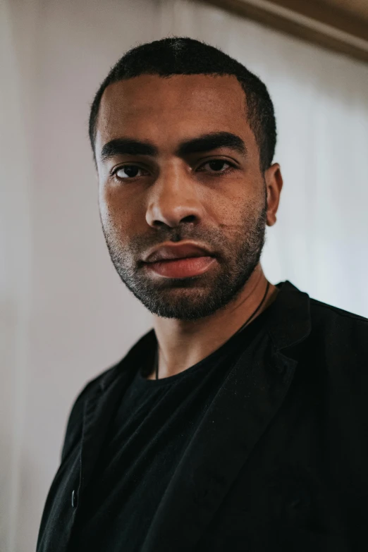 a close up of a person wearing a black shirt, inspired by Theo Constanté, pexels contest winner, hurufiyya, mid length portrait photograph, looking serious, lean man with light tan skin, ismail