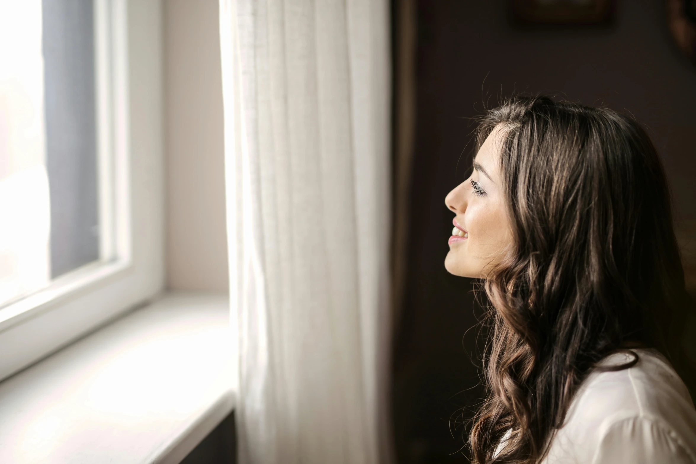 a woman looking out a window on a sunny day, pexels contest winner, romanticism, girl with dark brown hair, winking, waking up, looking upward