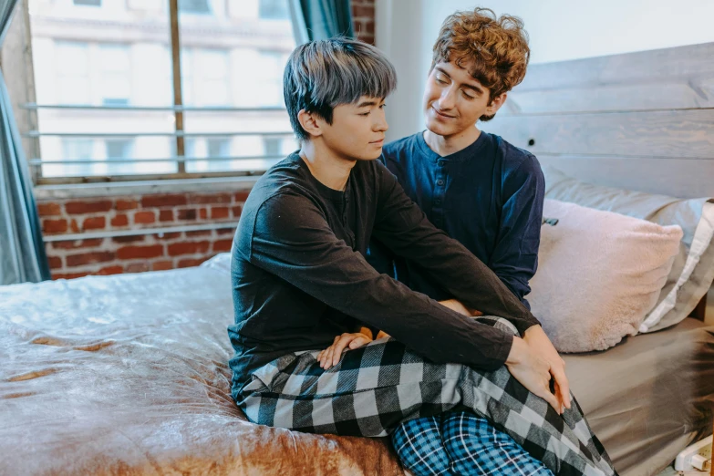 a couple of young men sitting on top of a bed, inspired by John Luke, trending on pexels, hong june hyung, elves sitting on the couch, lgbtq, supportive