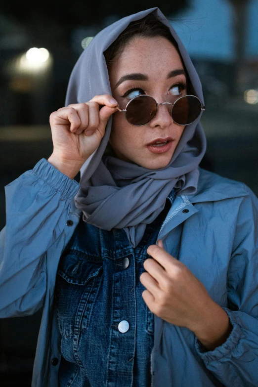 a woman wearing sunglasses and a blue jacket, a picture, trending on pexels, hurufiyya, veiled, jean jacket, grey, panels