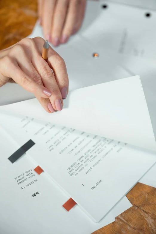 a person sitting at a table with papers and a pencil, pexels contest winner, letterism, up close, proof of concept, in house, uppercase letter