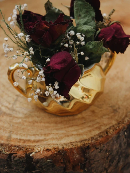 a vase filled with red roses sitting on top of a tree stump, wood and gold details, tea, upclose, modeled