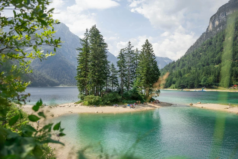 a body of water surrounded by trees and mountains, slovenian, multiple stories, pine trees, conde nast traveler photo