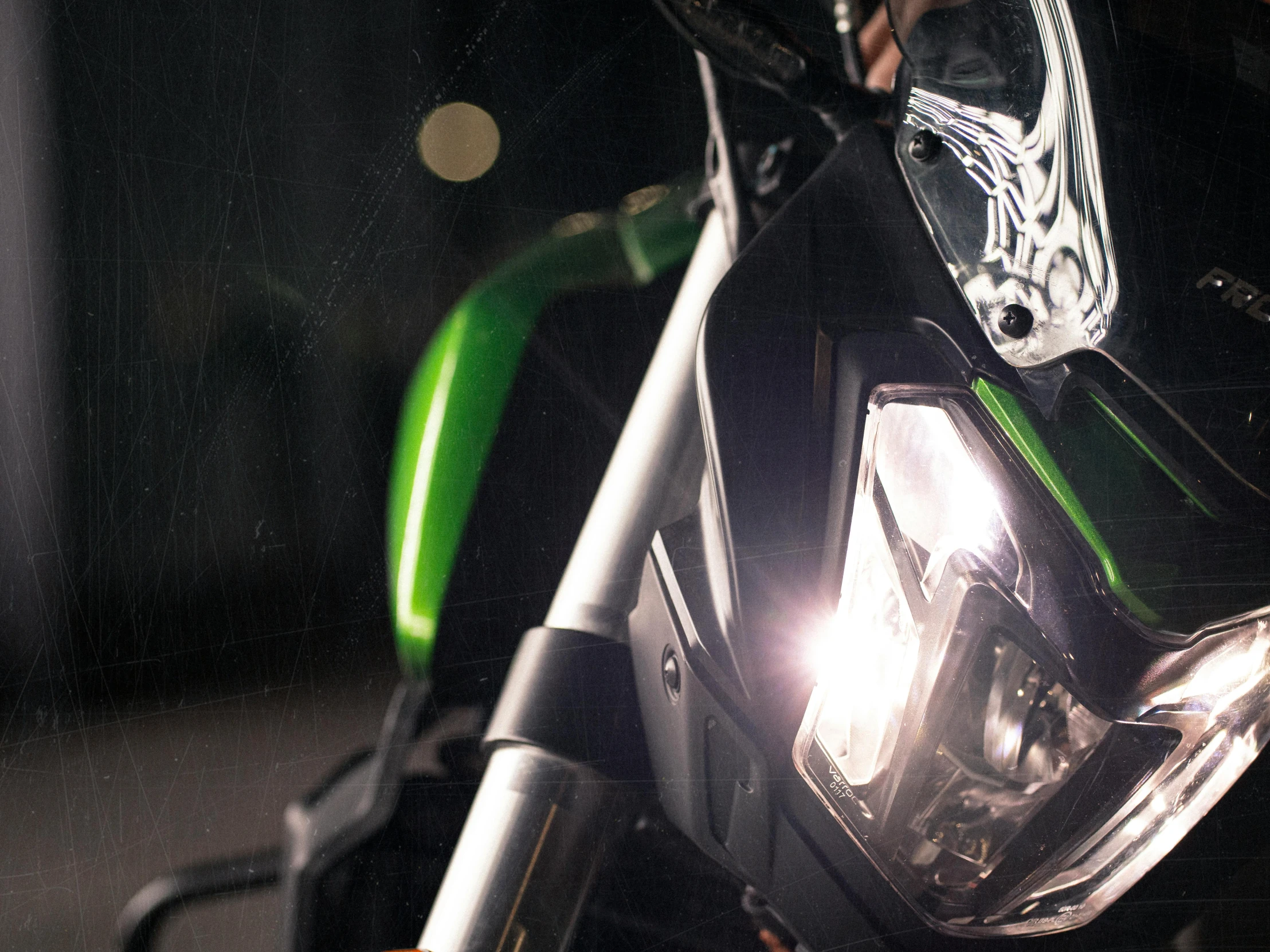 a close up of the headlight of a motorcycle, by Matija Jama, unsplash, photorealism, glowing green lights, 8k octane render uhd, banner, high quality upload