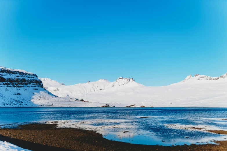 a body of water surrounded by snow covered mountains, balaskas, background image, iceland photography, clear blue skies